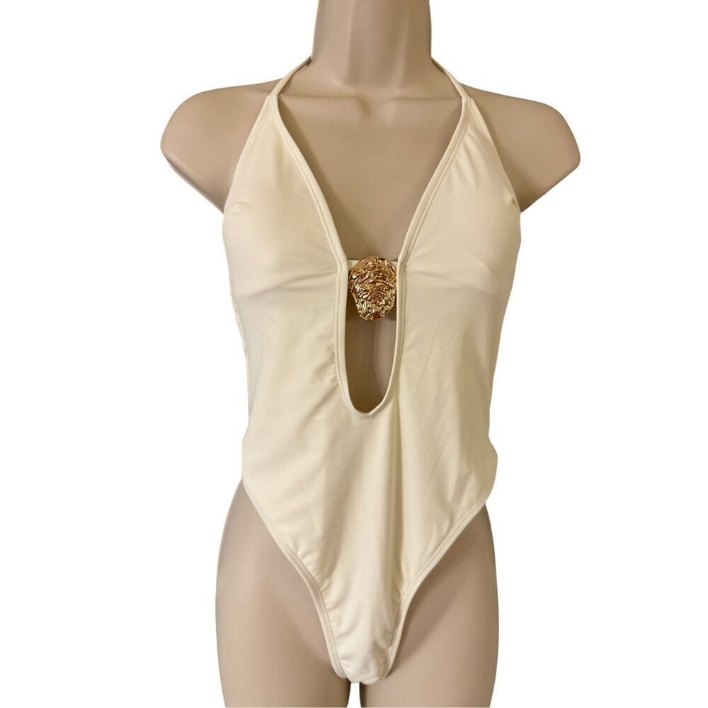 Plunge halter neck thong one piece swimsuit with metal shell medallion cream ivo